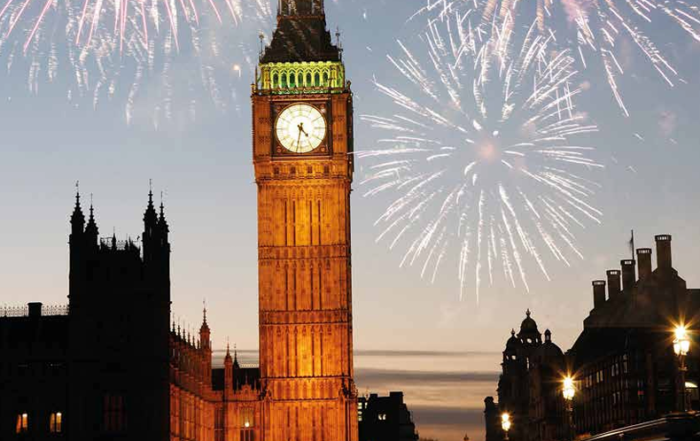Big Ben at dusk with fireworks in the sky, against a city skyline.